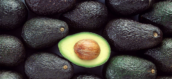 Pile of avocados, with one sliced open